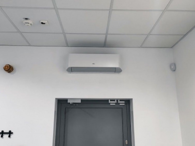 Klimatyzacja w pomieszczeniu obsługi, widać zamontowany klimatyzator split pod sufitem nad drzwiami.