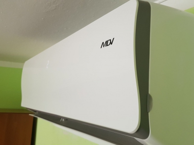 Zdjęcie klimatyzatora ściennego w zbliżeniu widać jego markę MDV klimatyzacja jest biało szara.