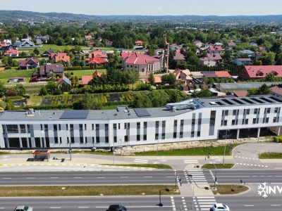 Przód budynku Erpix na dole widać ulicę podkarpacką za nim widok na Rzeszów. Na dachu panele słoneczne wraz z centralą wentylacyjną i klimatyzacja.