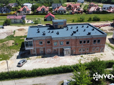 Widok na dach i czoło nowo powstałego budynku. Inwestycja w zakresie klimatyzacji i ogrzewania. Zdjęcie wykonane dronem.