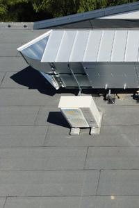 Centrala wentylacji mechanicznej VTS zamontowana na dachu, obok stoi jednostka zewnętrzna klimatyzacji firmy Fujitsu