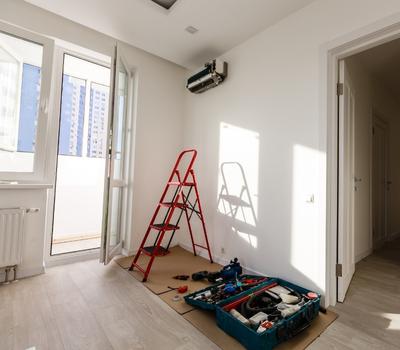 Montaż klimatyzacji w mieszkaniu, widać narzędzia, klimatyzator już nawieszony na ścianie.