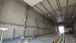 Wnętrze budynku do prześwietlania ciężarówek, widoczna instalacja odciągów